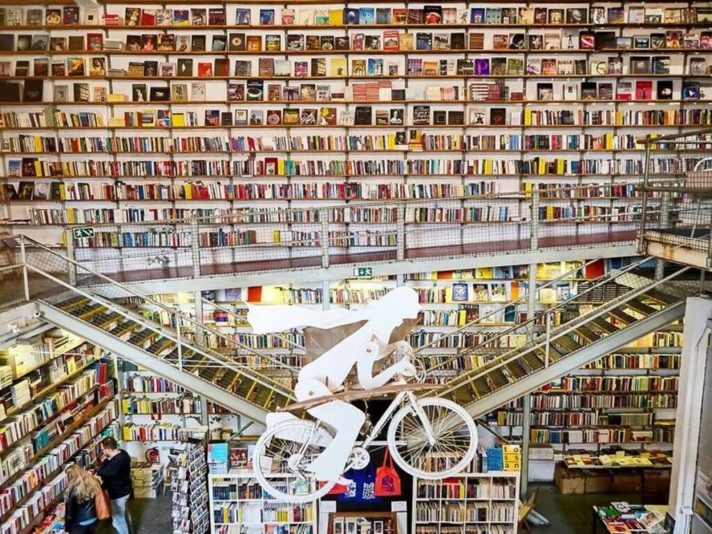 Industrial bookstore interior with flying bicycle sculpture at Ler Devagar in Lisbon LX Factory