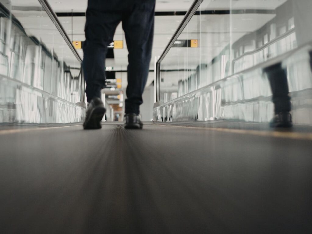 Long airport terminal corridor with distance markers to gates
