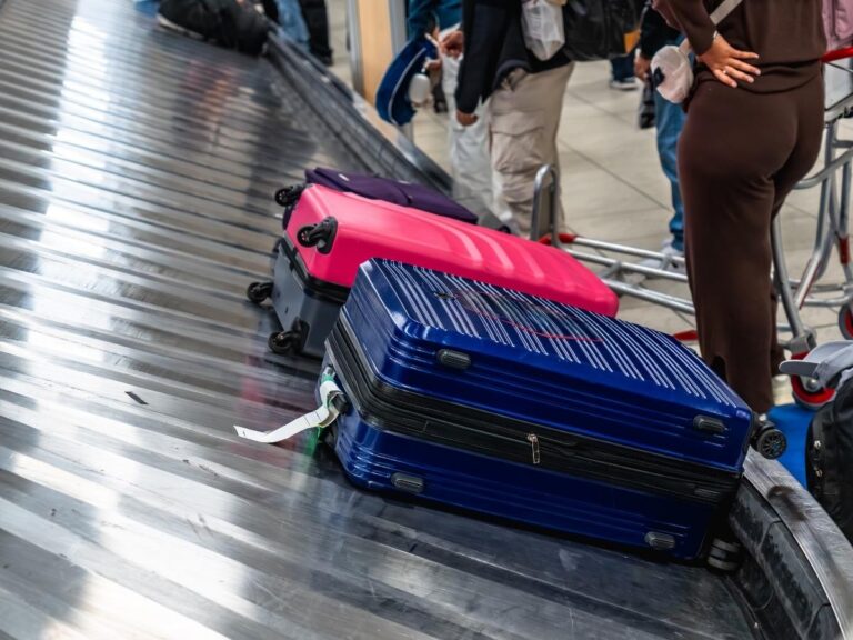 Suitcases on baggage claim carousel at airport terminal