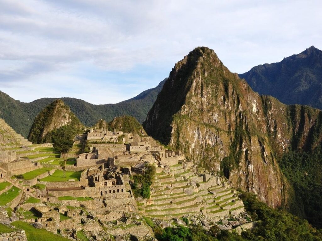 Ancient Machu Picchu citadel at sunrise with Andean mountains in Peru