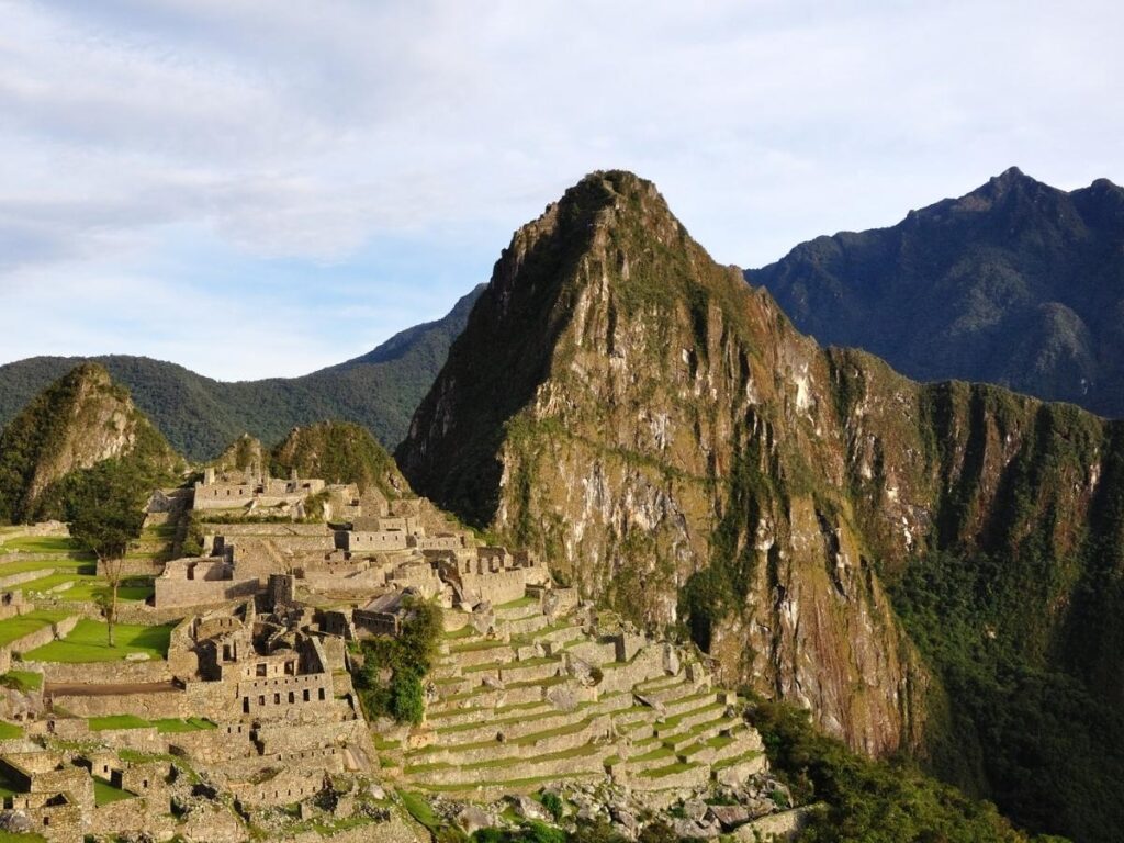 Ancient Inca ruins of Machu Picchu at sunrise with mist and mountains in Peru