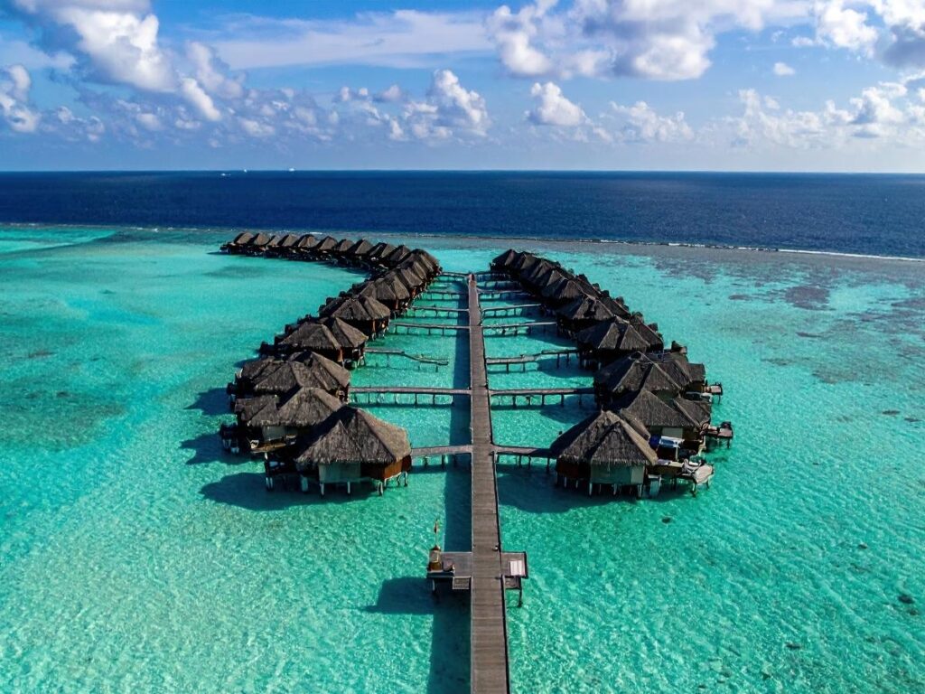 Overwater bungalow villa in crystal clear turquoise lagoon in Maldives