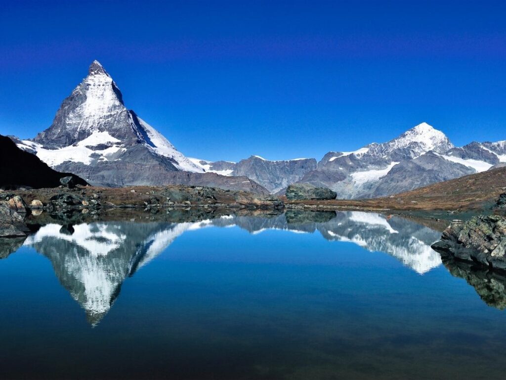 The Matterhorn peak reflected in alpine lake in the Swiss Alps
