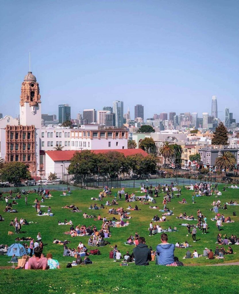 San Francisco skyline seen from the grassy hillside of Mission Dolores Park