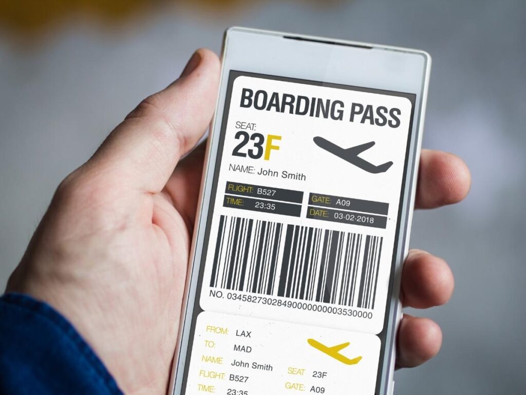 Hand holding smartphone with digital boarding pass at airport