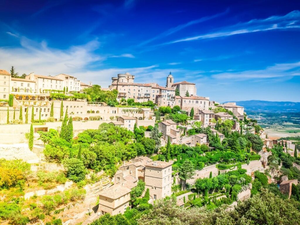 Gordes village perched on hilltop in Provence France with stone houses and lavender fields
