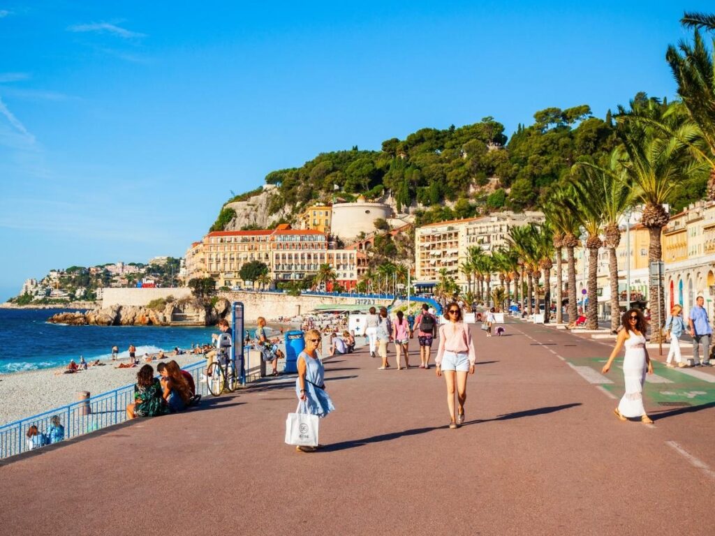 Promenade des Anglais beachfront walkway with palm trees and turquoise Mediterranean Sea in Nice French Riviera