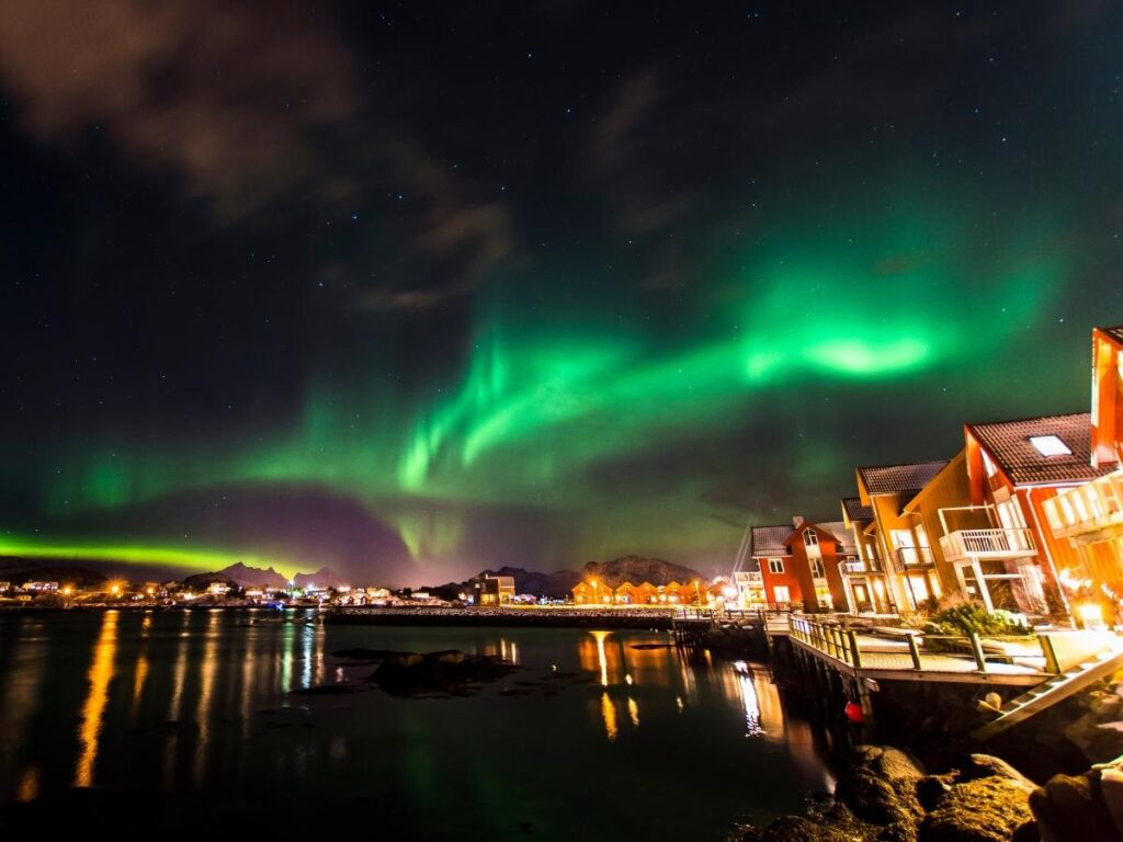 Green and purple northern lights dancing over Tromsø Norway Arctic landscape