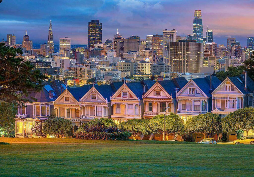 pastel Painted Ladies houses at Alamo Square with San Francisco skyline behind