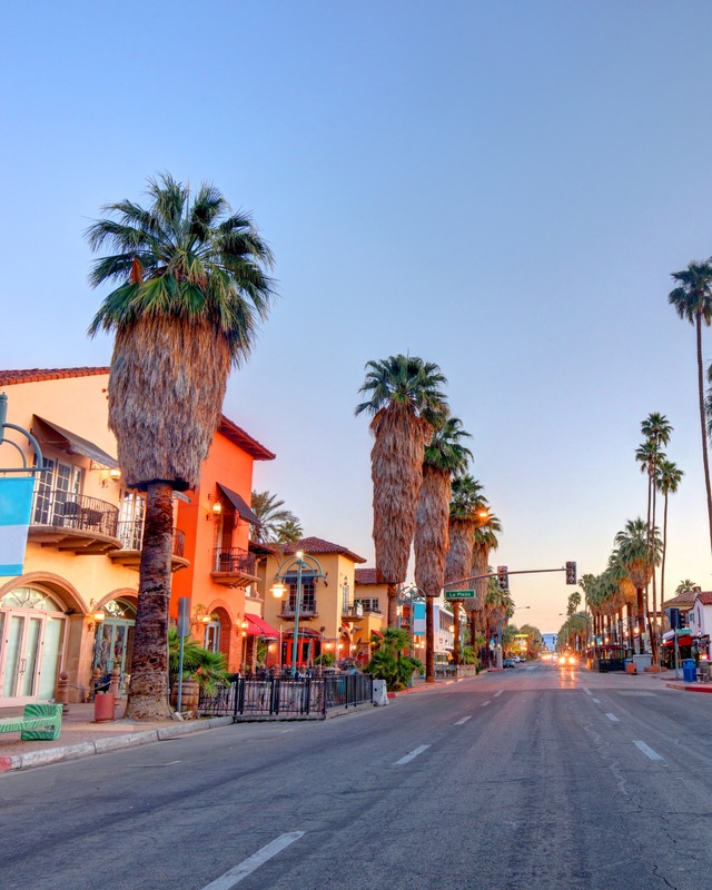 Palm Canyon Drive lined with shops, palm trees, and mountain views in downtown Palm Springs