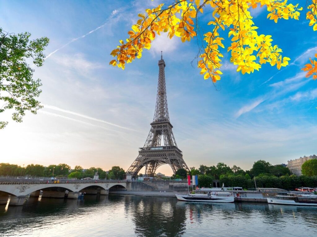 Eiffel Tower sparkling at night over Seine River in Paris France