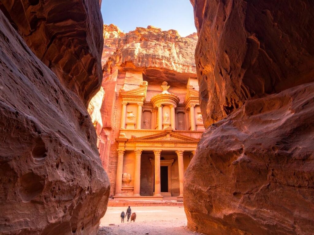 The Treasury carved into rose-colored sandstone cliffs in Petra, Jordan