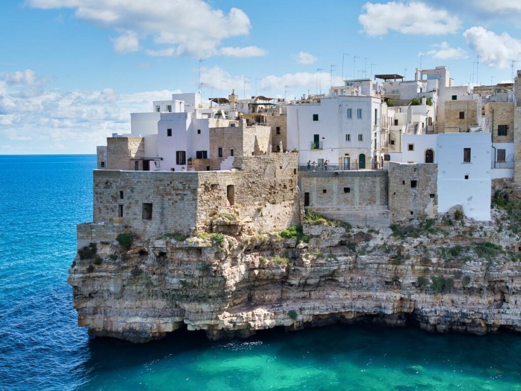 Polignano a Mare whitewashed buildings perched on limestone cliffs above the Adriatic Sea