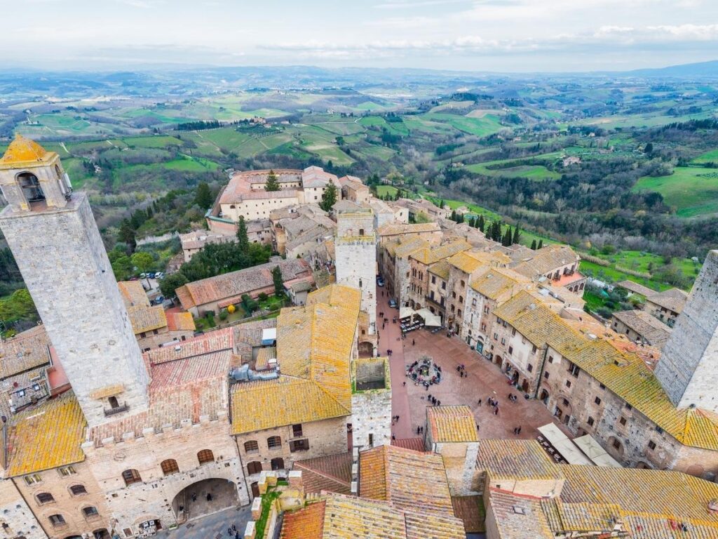 Medieval towers of San Gimignano rising above the Tuscan hills at sunset