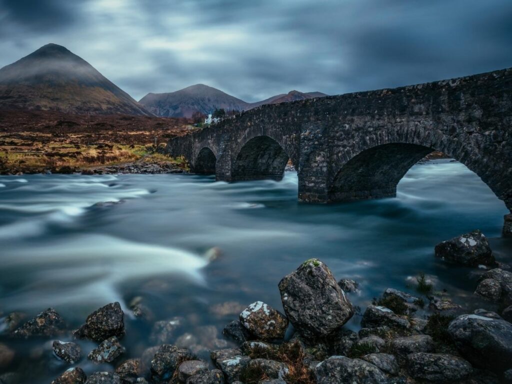 Old stone bridge at Sligachan with dramatic Cuillin mountain range Isle of Skye
