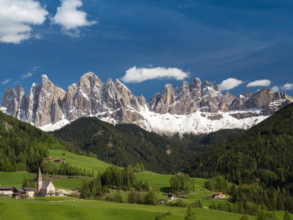 Small church in St. Magdalena village with dramatic Dolomite mountain peaks behind