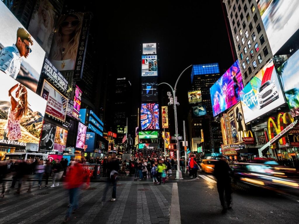 Times Square in New York City illuminated at night with neon signs and crowds
