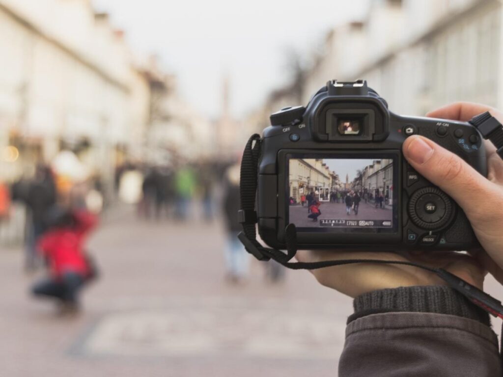  Photographer reviewing camera settings and photos on LCD screen while traveling