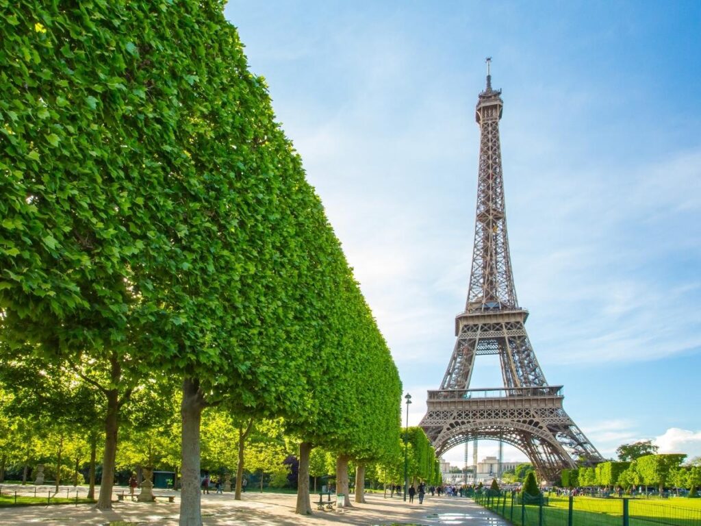 Creative low angle view of Eiffel Tower through Parisian street with autumn leaves