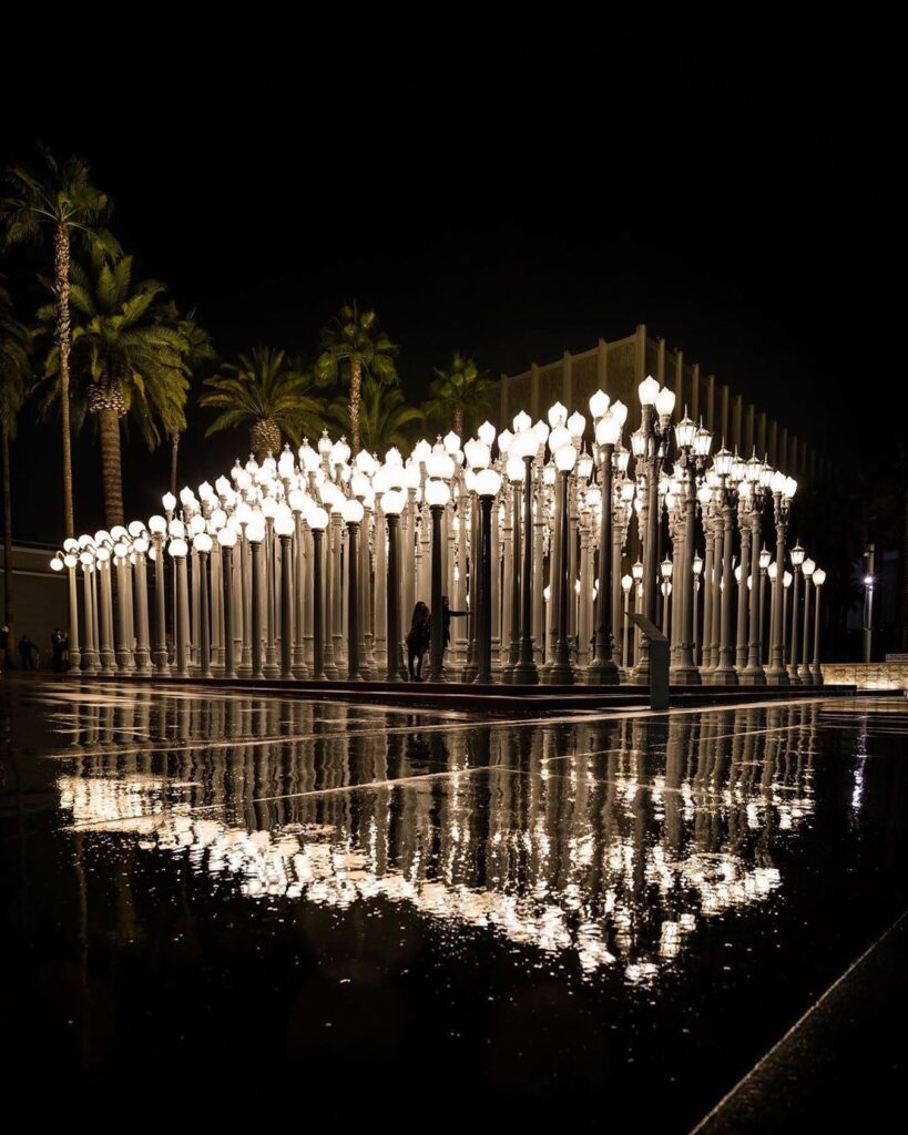 Urban Light installation with glowing vintage street lamps outside LACMA at night