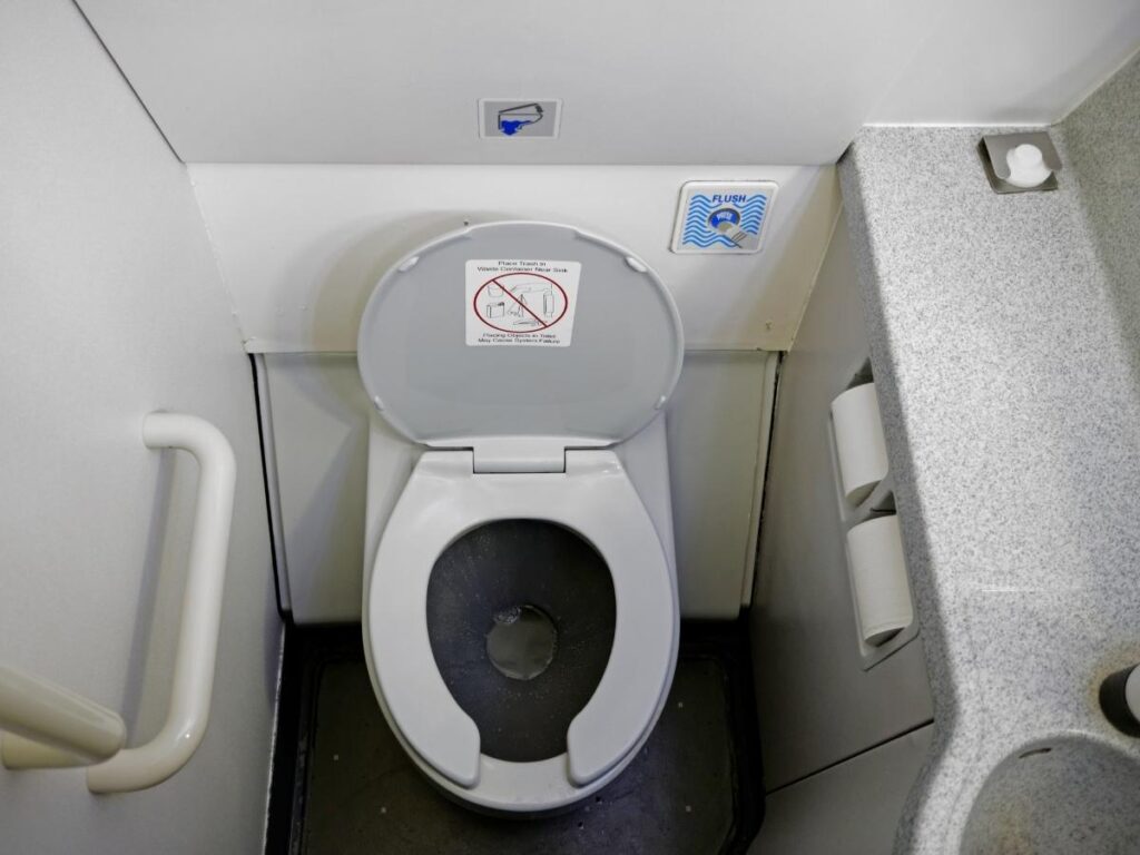 Cramped airplane lavatory interior showing limited space