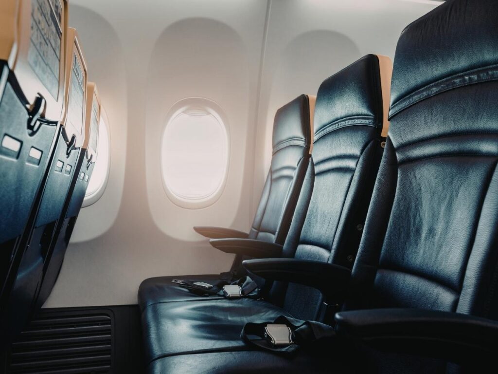Close-up of airplane seat and tray table in economy cabin
