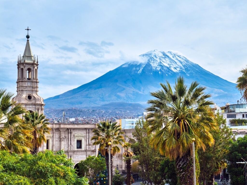 White sillar stone colonial architecture in Arequipa Peru with El Misti volcano visible in the background on a clear day