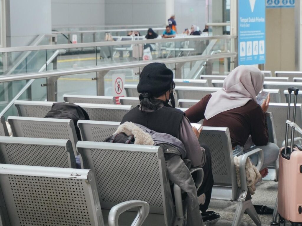 Traveler sitting peacefully at airport gate before boarding flight