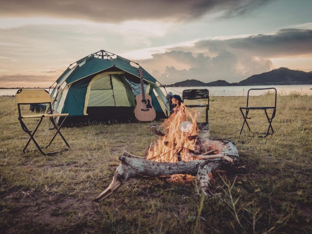 Tent camping setup at scenic campground as affordable road trip accommodation option