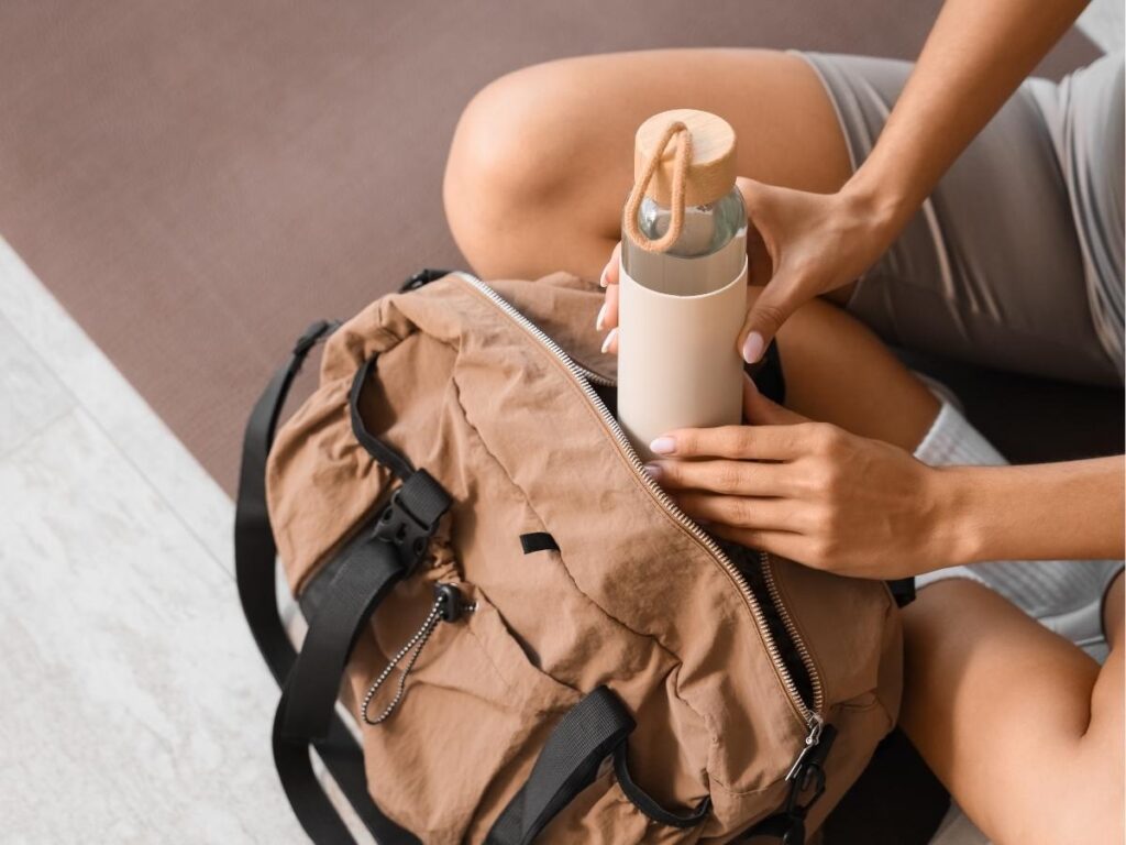 Nomader collapsible water bottle clipped to travel backpack