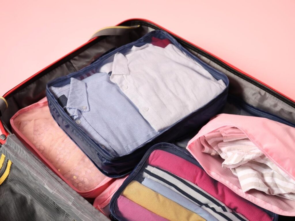 Colorful packing cubes organizing clothes inside an open suitcase