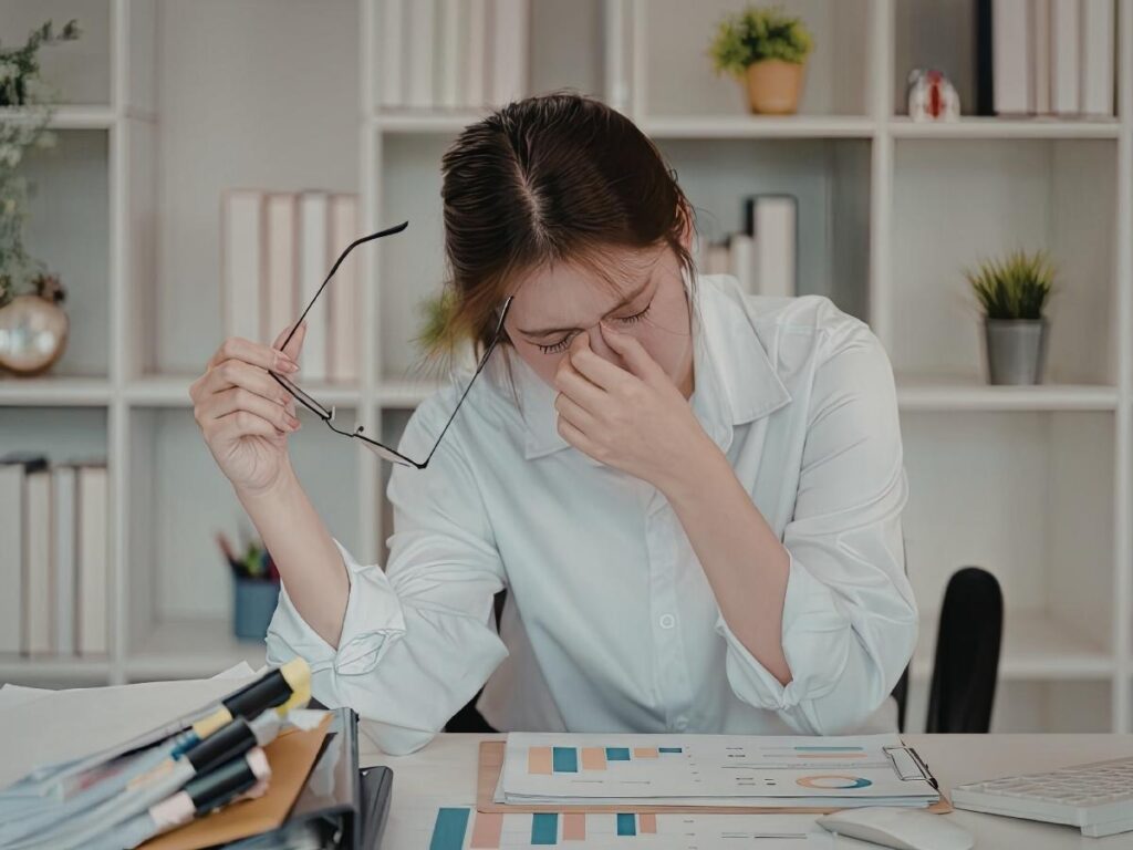 Traveler looking stressed while sorting through paperwork and documents at a rental apartment