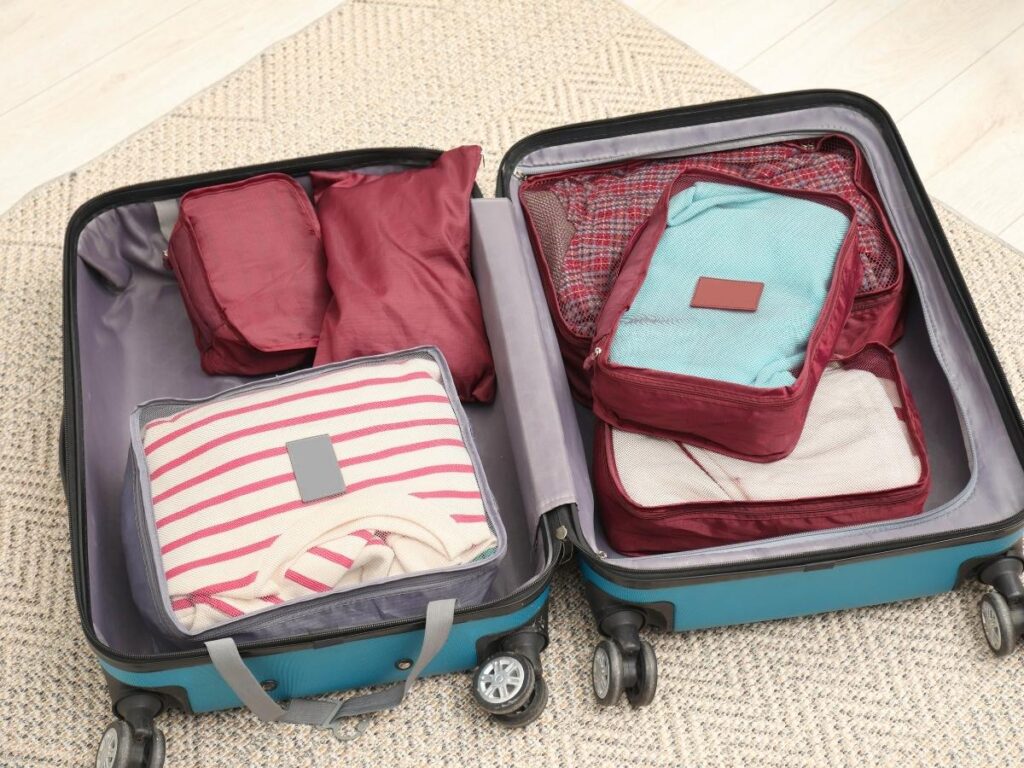 Compression packing cubes organized inside a suitcase with folded heavy winter clothing