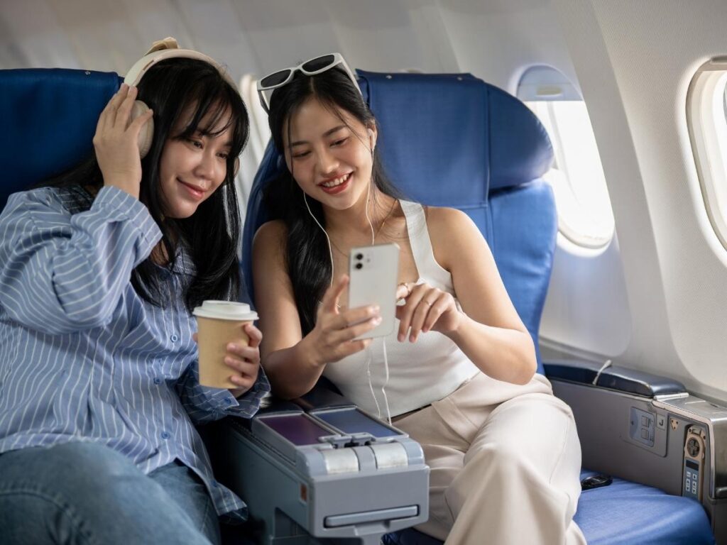 Two friends talking and supporting each other during airplane flight