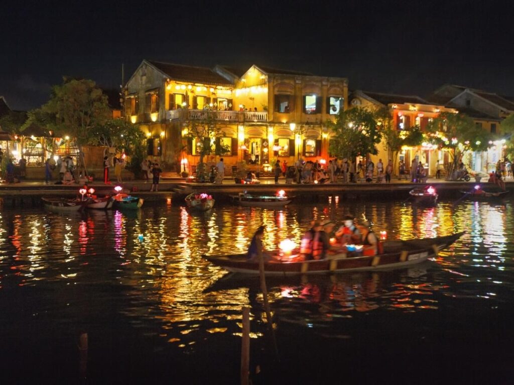 Paper lanterns glowing over the ancient town streets of Hoi An Vietnam reflected in the Thu Bon River at night