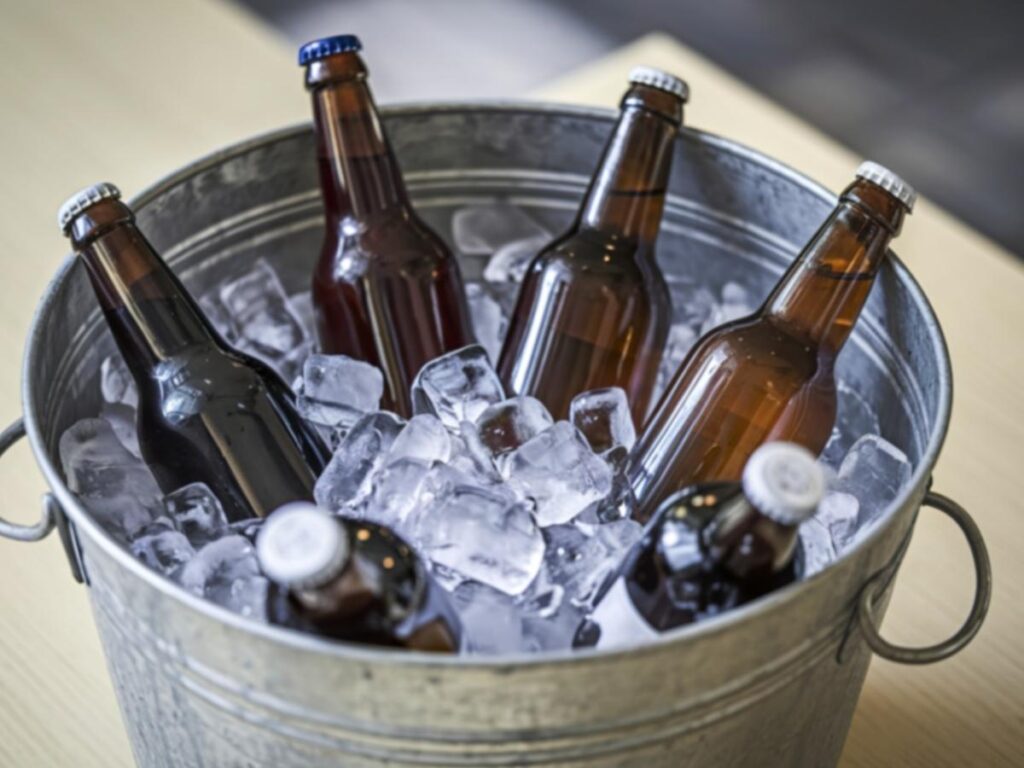 Hotel ice bucket on desk with ice machine in background
