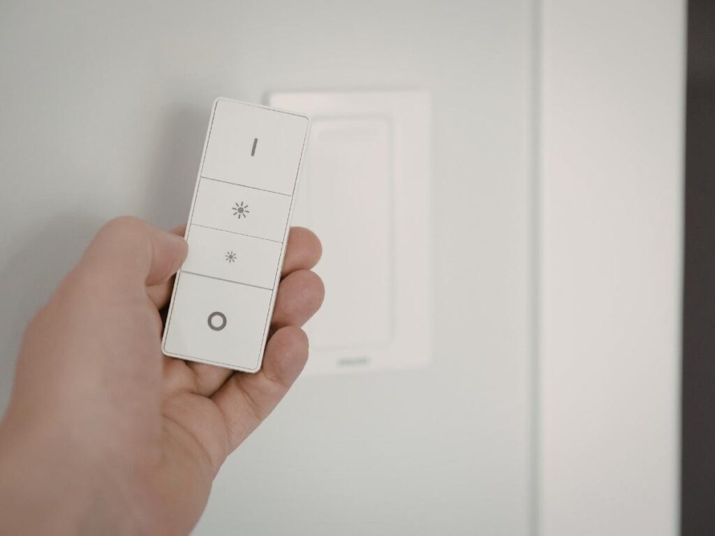 Woman wiping hotel room remote control and light switches with cleaning wipe