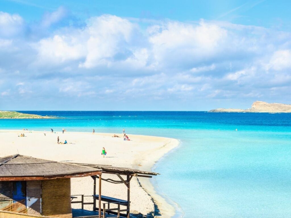 Tourist using required straw mat on La Pelosa Beach Sardinia