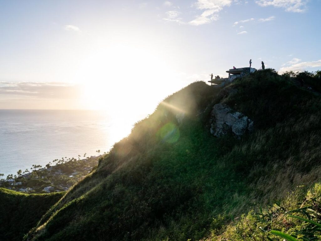 Panoramic sunrise view from Lanikai Pillbox Trail overlooking turquoise ocean and Mokulua Islands