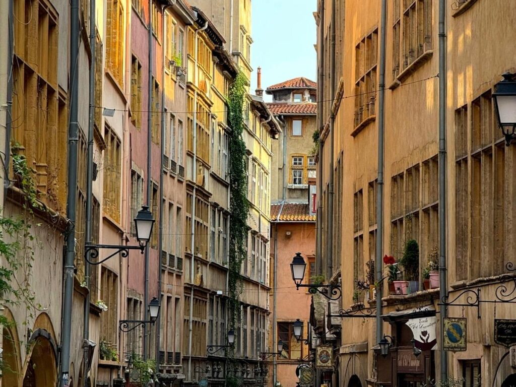 Quiet residential street in Lyon, France with a boulangerie and people walking on a weekday morning