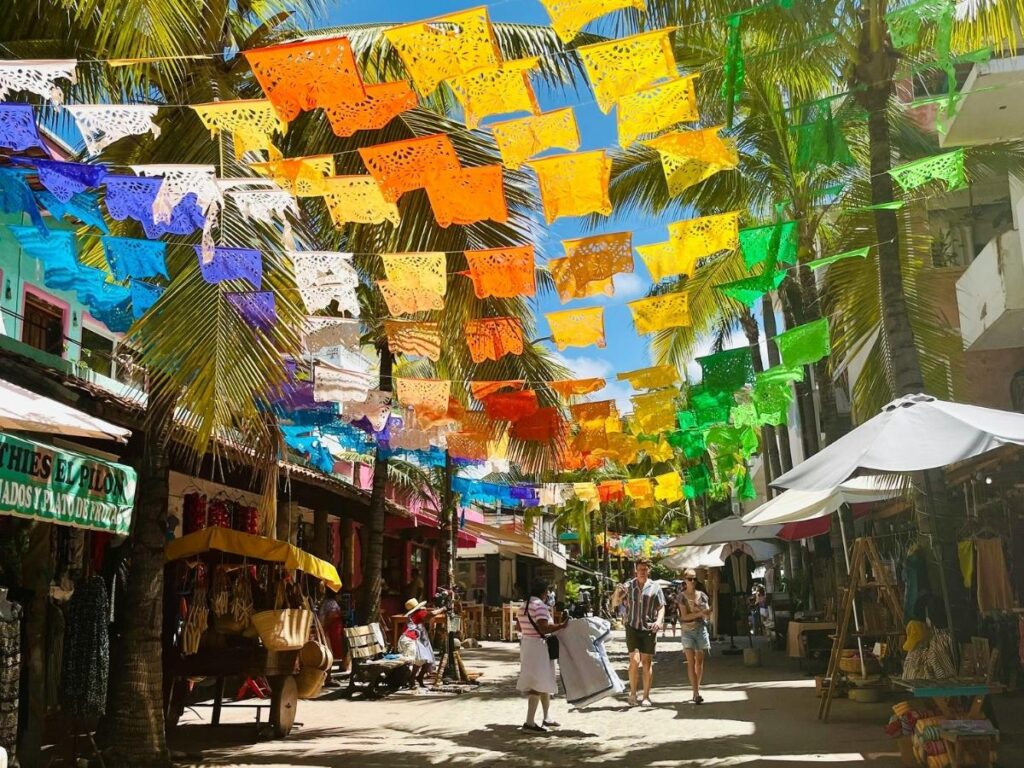 Colourful local market street in Oaxaca, Mexico with vendors and residents going about their morning