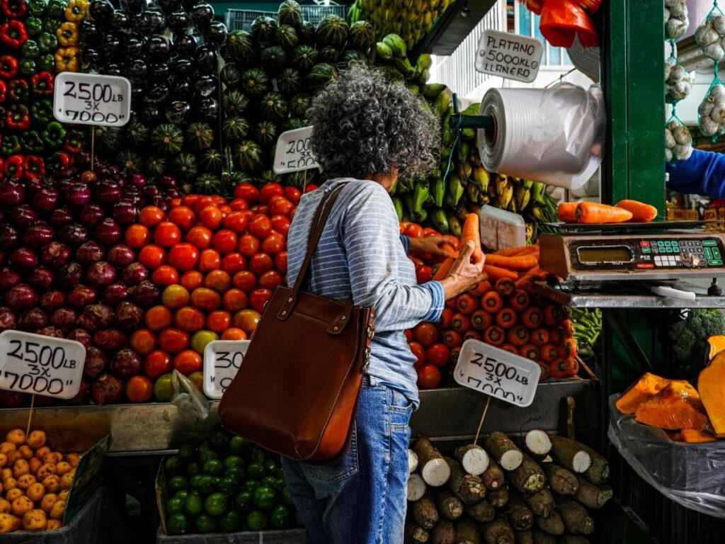 Traveler shopping for fresh produce at a colorful local market while on vacation