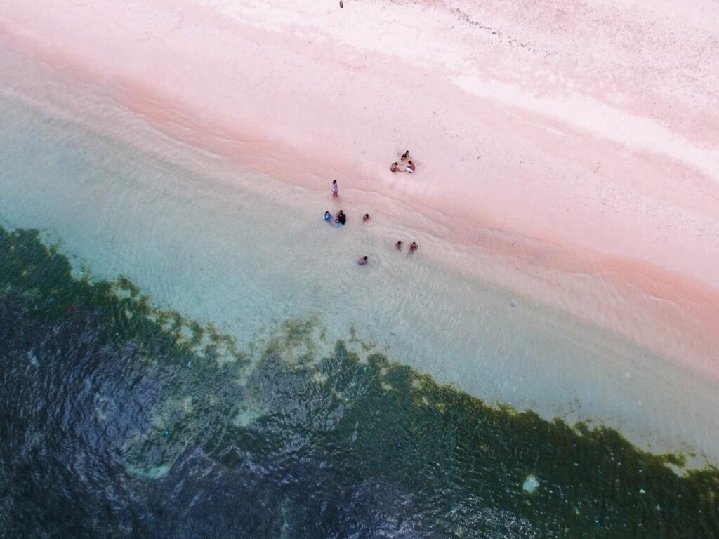 Pink Beach on the east coast of Lombok Indonesia with crystal clear turquoise water and Mount Rinjani in the distance