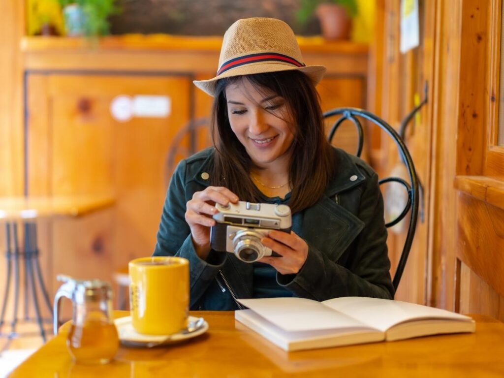Traveler sitting at a local café with a coffee and notebook, settling into daily life abroad