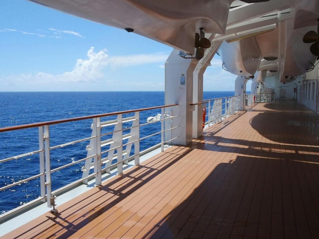 A spacious cruise ship balcony cabin overlooking the ocean
