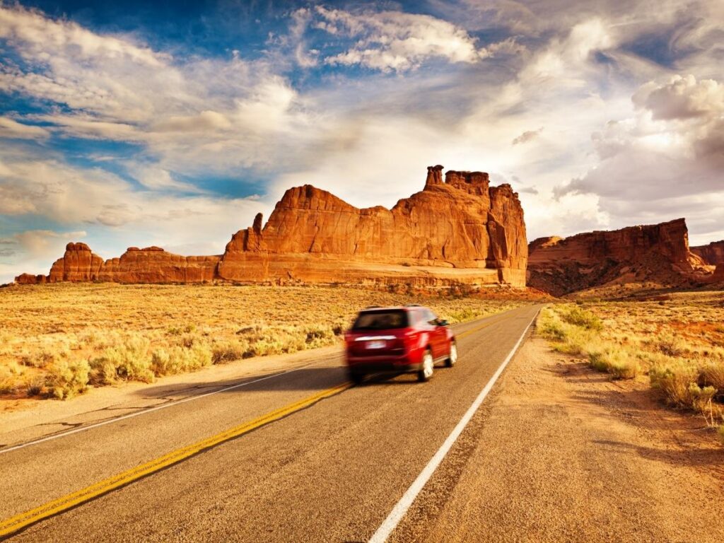 Open desert highway driving through Utah on a national parks road trip