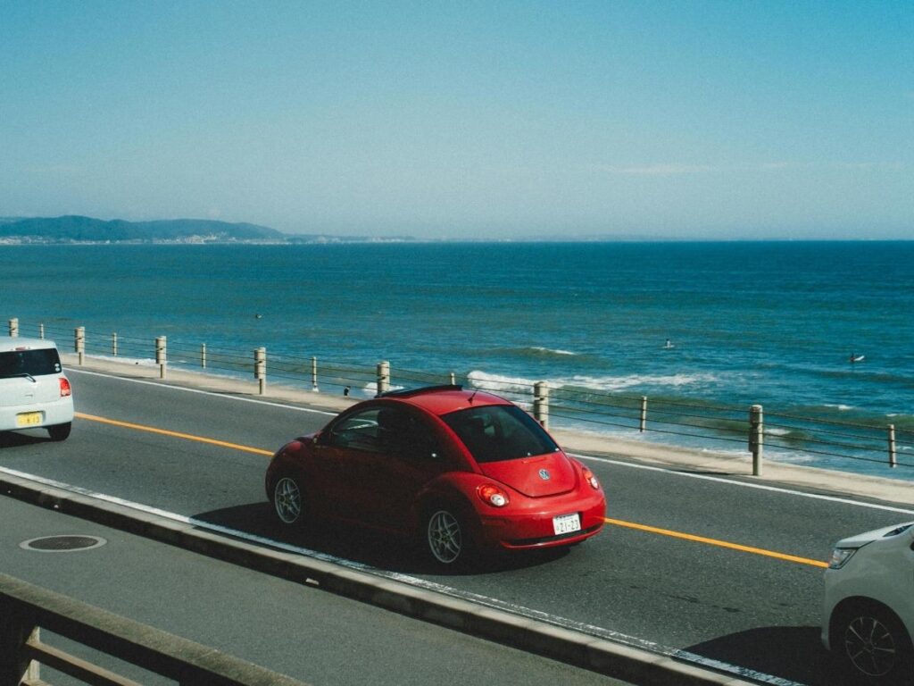 Car driving along scenic Pacific Coast Highway with ocean views during road trip