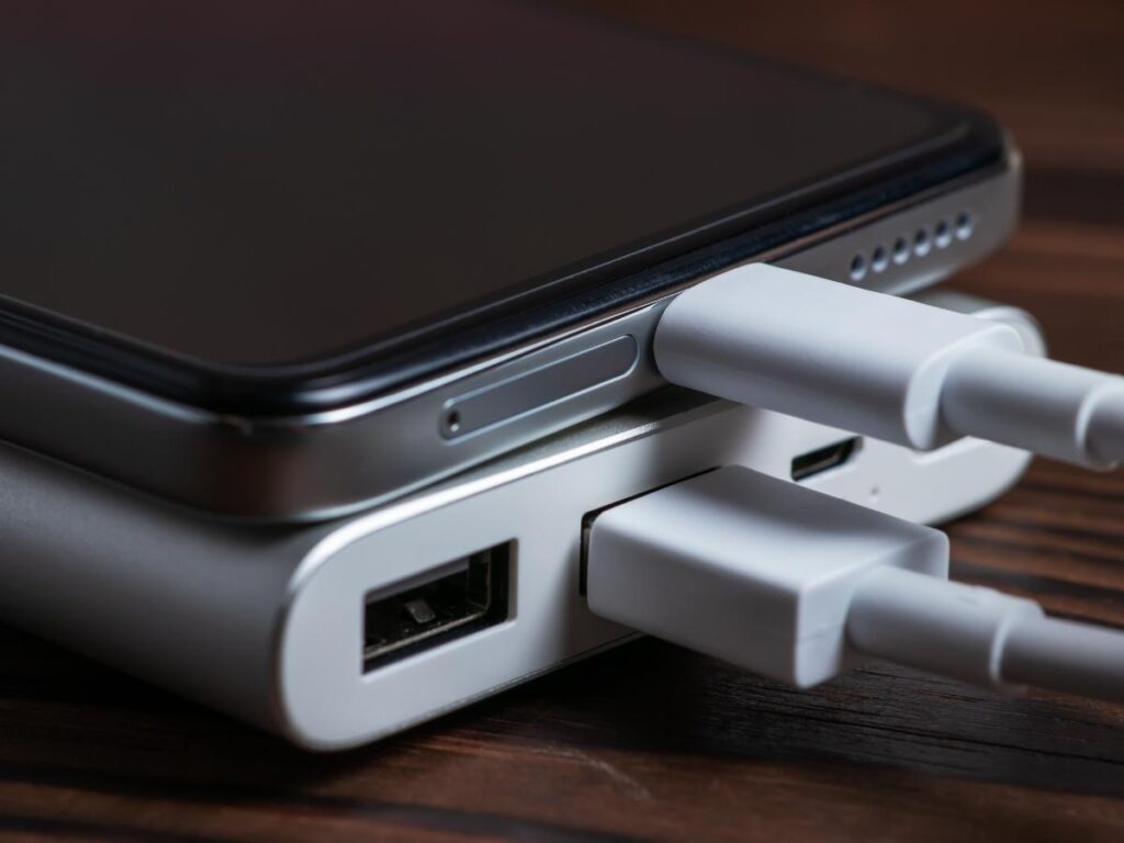 High-capacity portable charger connected to a smartphone on a travel day