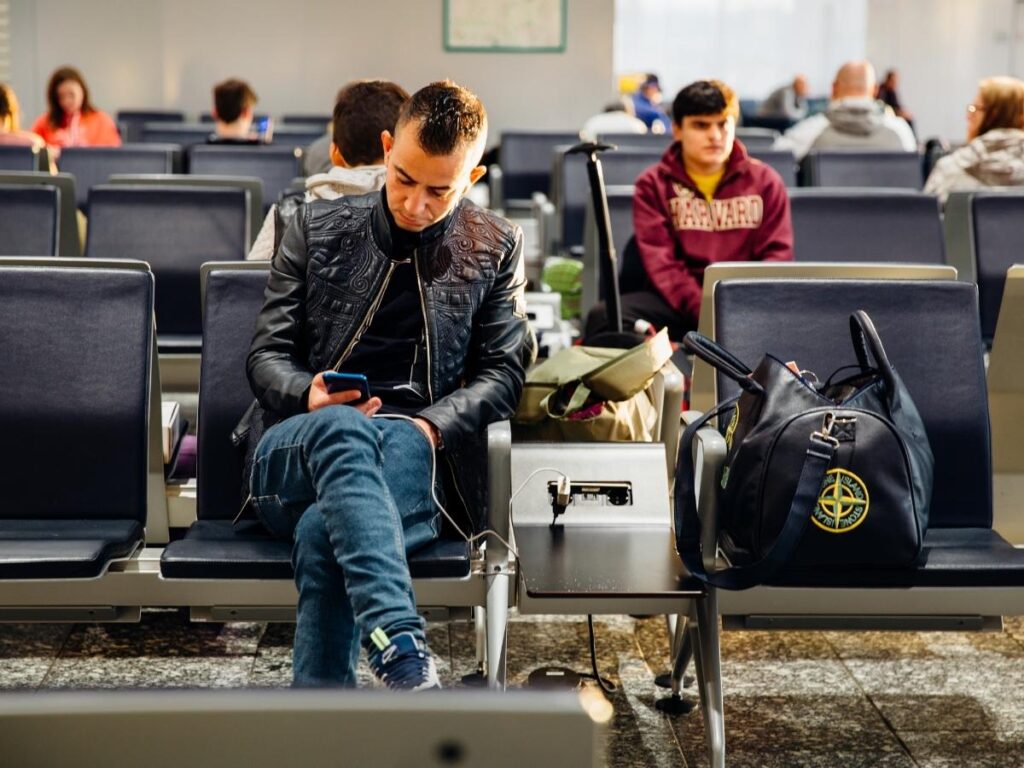 Row of public USB charging ports at an airport terminal showing the security risk of plugging in devices to unknown public charging stations