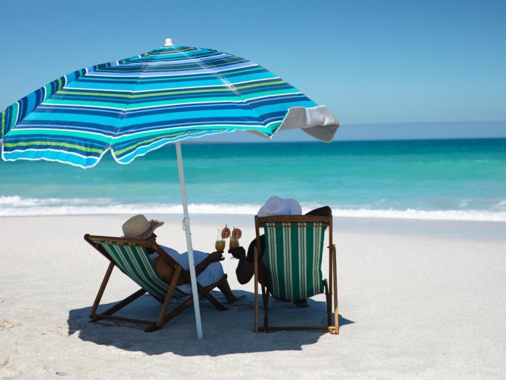 Couple relaxing on a sunny beach enjoying a stress-free vacation after smart travel budgeting